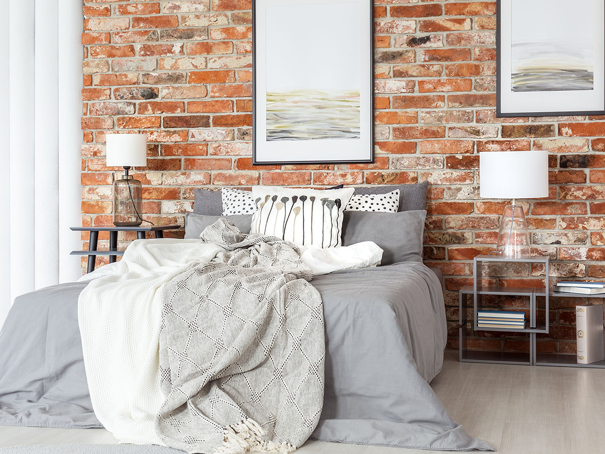 A bed with dark colored sheets
